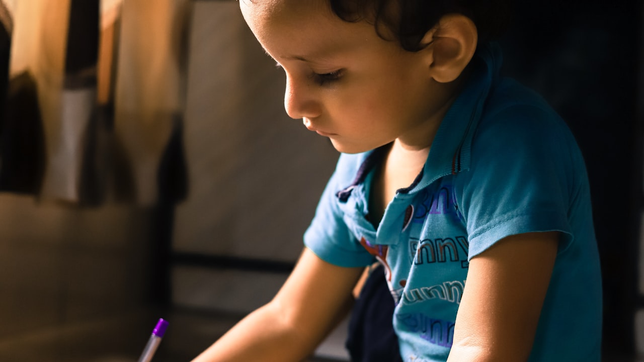 Un bambino chino sul foglio mentre scrive: nella disortografia la fatica sta nella scelta delle lettere, non nel gesto