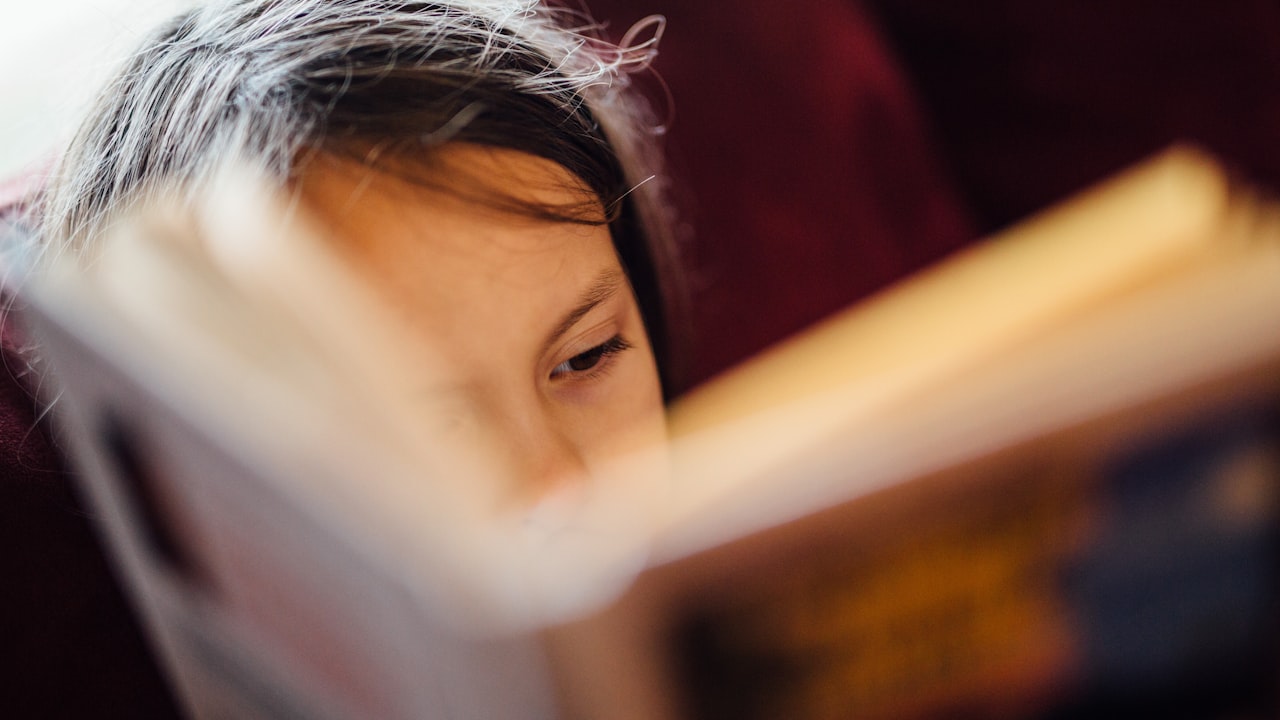 Un bambino concentrato sulle pagine di un libro: nella dislessia la fatica è tutta nella decodifica, non nella comprensione