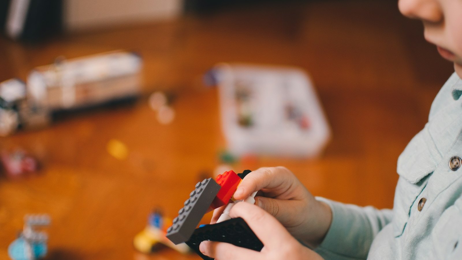 Le mani di un bambino che monta mattoncini colorati giocando da solo: nei sintomi di autismo conta l'insieme dei segnali, osservato nel tempo