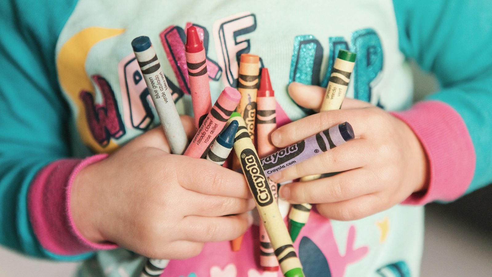 Le mani di una bambina stringono un mazzo di pastelli colorati: dalla valutazione neuropsicologica esce un profilo con punti di forza e fatiche, non un'etichetta