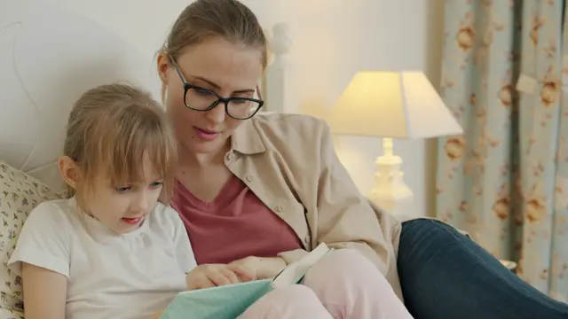 Una mamma e una bambina leggono insieme un libro: la lettura è il punto in cui la dislessia spesso si manifesta per primo