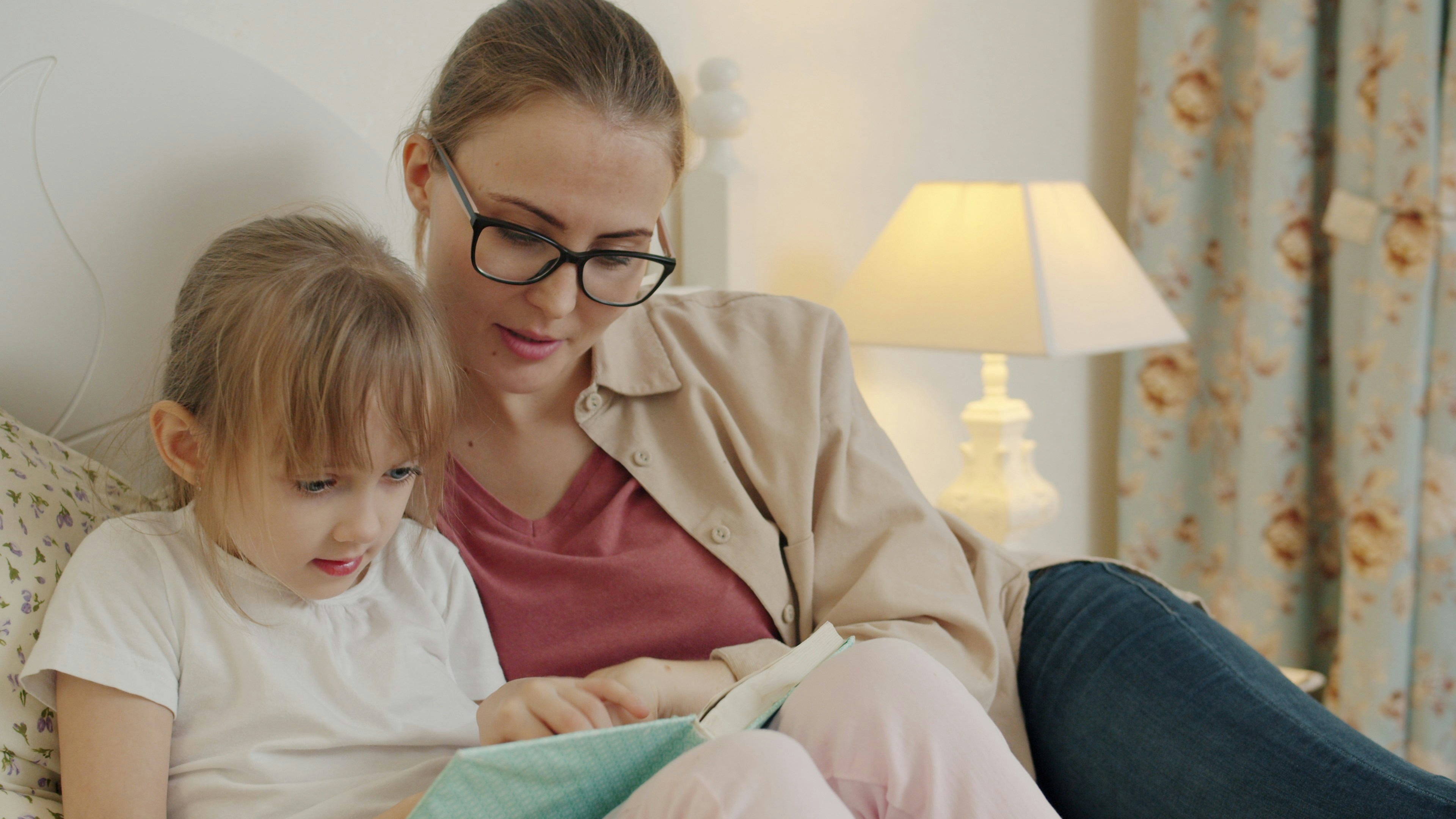 Una madre e una bambina leggono insieme un libro
